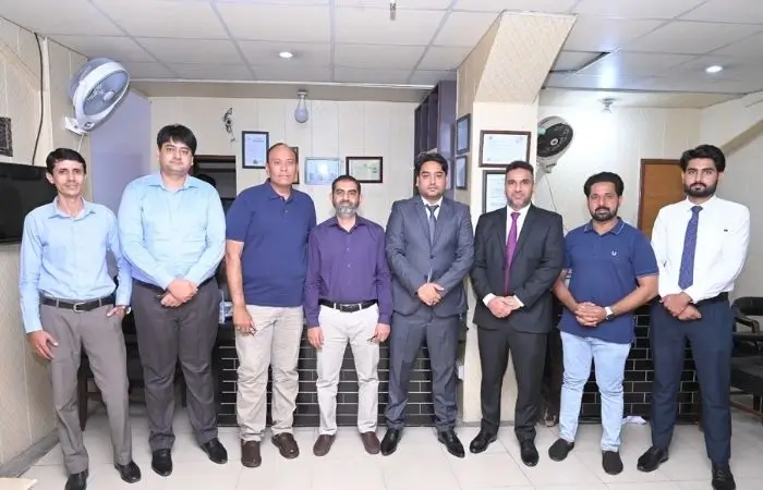 دی فلائٹ سنٹر کے اسٹاف ممبرز دفتر کے اندر گروپ پورٹریٹ کے لیے اکٹھے کھڑے ہیں